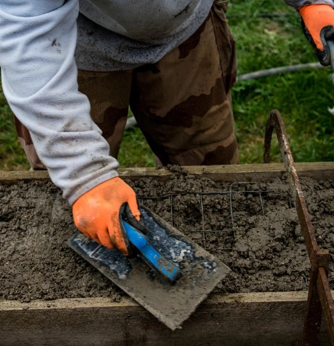 worker smoothing concrete slab during foundation repair in Los Angeles